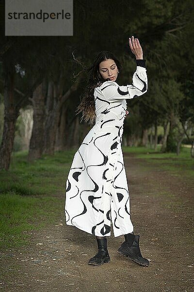 Young woman dancing outdoors. Dance performance in the park