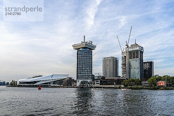 Amsterdam  Netherlands  May 6  2022: Scenic view at sunset of the IJ waterway bank. Amsterdam skyline featuring the Eye Film Museum and the A'DAM tower