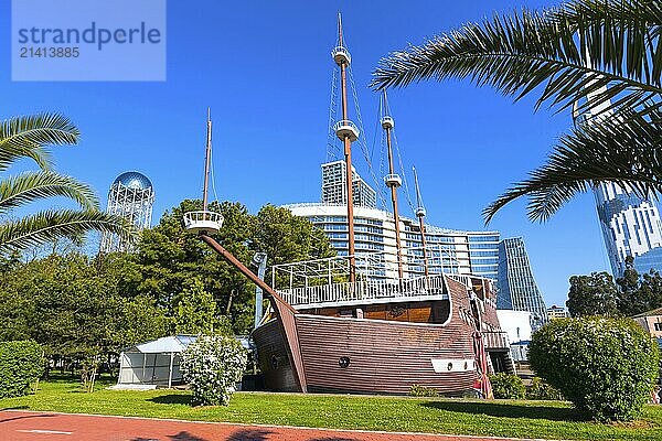 Batumi  Georgia  April 30  2017: Park with palm trees  ship and modern houses near promenade boulevard of georgian summer resort  Asia