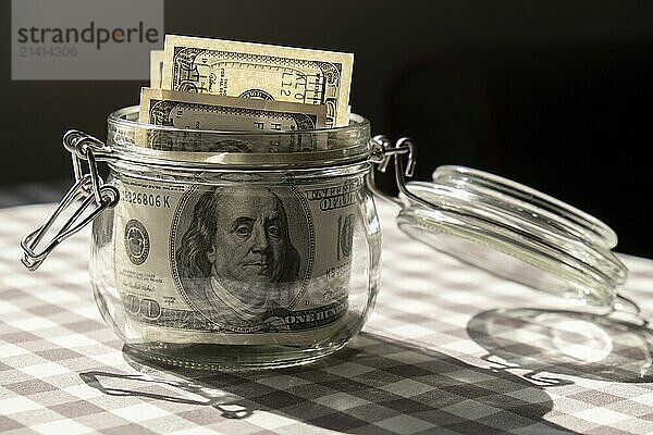 Dollar banknote saving money in glass jar. Consumption and economy Collecting money. Tips. Business  finance  saving  banking and people concept. Extra money  passive income. Saving for travel  crisis  house  car  education  retirement