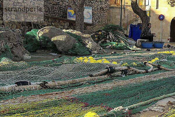 Puerto de Cala Figuera  Spain  22 Janaury  2024: Mallorcan fisherman mending nets and repairing fishing lines in the harbor of Cala Figuera on Mallorca  Europe