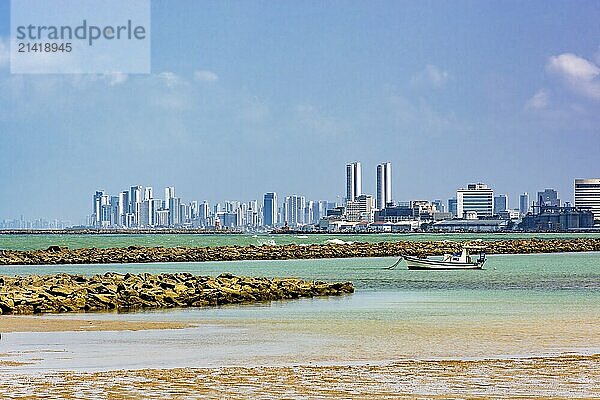 Boat on the beach in the city of Olinda with the skyscrapers of Recife in the background