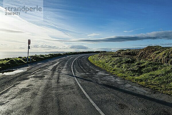 Scenic view of the Wild Atlantic Way in Ireland near Kinsale with green hills at sunset