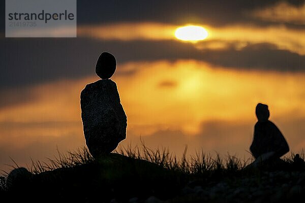 Two balanced stones in the foreground of a colourful sunset  Seegarten  Allensbach  Lake Constance  Baden-Württemberg  Germany  Europe