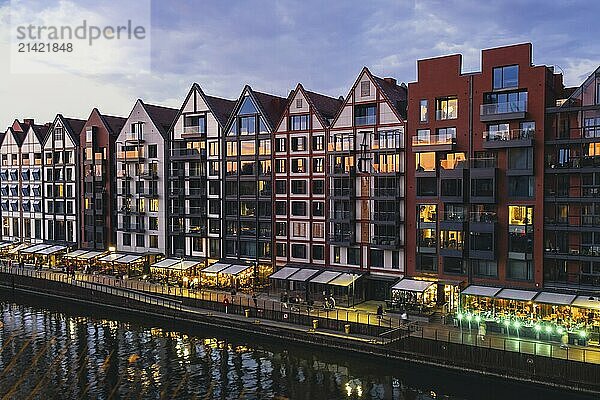 Old town in Gdansk at summer dusk Poland. Sunset night view from the window rooftop on new modern architecture buildings Hotels to stay in Gdansk Place to eat over Motlawa river Wyspa Spichrzow Travel attraction