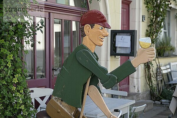 Wooden figure with wine glass in front of a pub  Iphofen  Lower Franconia  Bavaria  Germany  Europe