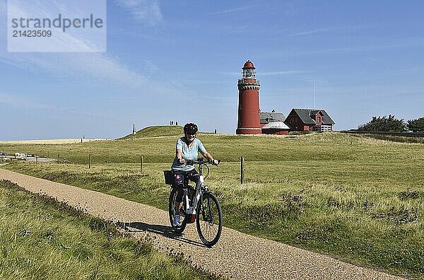 Woman with bicycle at Bovbjerg lighthouse in Denmark