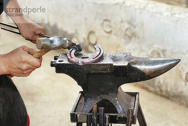 Blacksmith working on the anvil  making a horseshoe