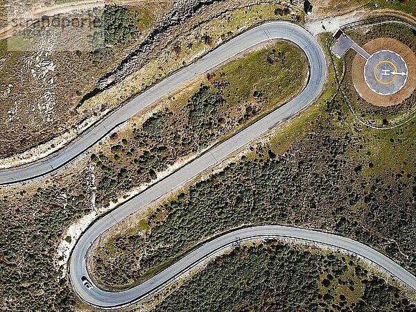 Aerial view of winding road. Splendid morning scene of asphalt roadway. Heliport for emergency helicopters. Aerial view of heliport for emergency helicopter landings. Traveling concept background