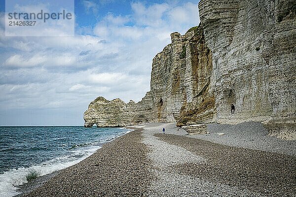 Etretat  france  23-04-2024  woman walking on the beach at the famous calck cliffs in normandy france near etretat  view from the beach