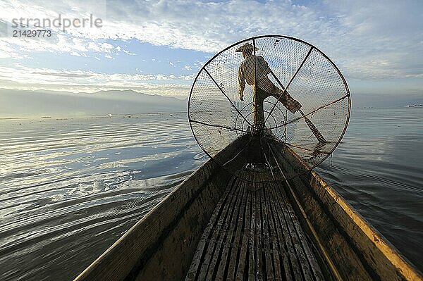 05.03.2014  Nyaung Shwe  Shan State  Myanmar  Asia  A single-leg rower paddles along the northern shore of Inle Lake early in the morning. The lake is located in Shan State in the centre of Myanmar and is home to the Intha people  who live mainly from fishing and farming  Asia