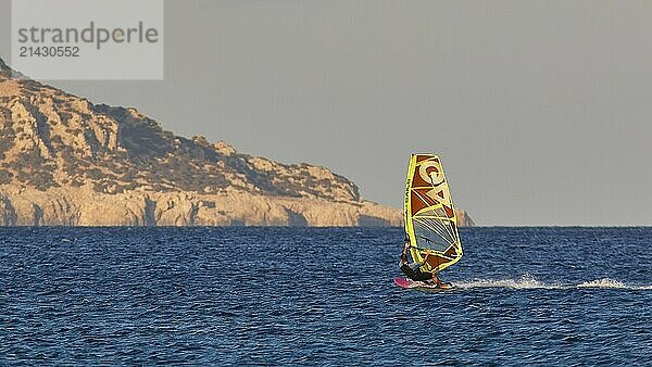 A windsurfer gliding off the coast in calm seas  windsurfer  Meltemi windsurfing spot  Devils Bay  Paralia Vatha  Vatha Beach  south-east coast  Karpathos  Dodecanese  Greek Islands  Greece  Europe