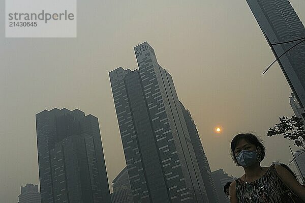 20.06.2013  Singapore  Republic of Singapore  Asia  A woman wearing a breathing mask walks through the hazardous smog that cloaks the skyscrapers in the Marina Bay business district and is mainly caused by illegal slash-and-burn agriculture in neighbouring Sumatra and Borneo  Asia