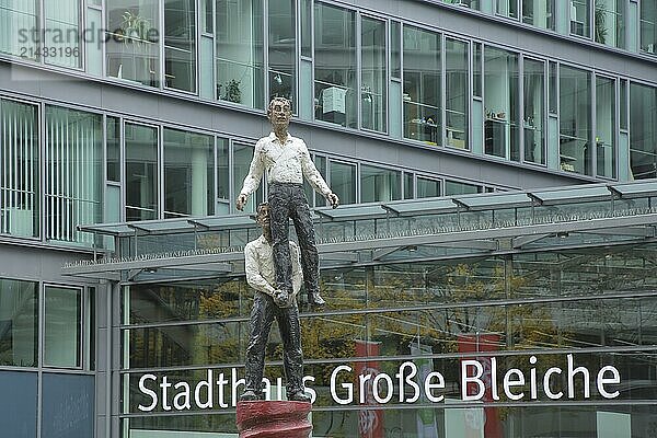 Townhouse with sculpture Two Men by Stephan Balkenhol 2001  male figure  standing on one leg  carrying  lifting  lifting  high  above  strength  acrobatics  stained glass window  inscription  glass building  Große Bleiche  historic city centre  Mainz  Rhine-Hesse region  Rhineland-Palatinate  Germany  Europe