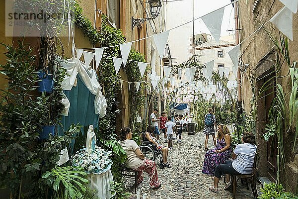 Decorated alley and celebrating people  feast of the Madonna of Regnos Altos  Bosa  district of Oristano  Sardinia  Italy  Europe