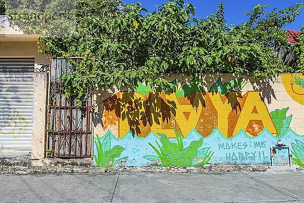 Playa del Carmen Mexico 04. February 2022 Typical street road and cityscape with cars and buildings and wall paintings of Luis Donaldo Colosio Playa del Carmen in Mexico