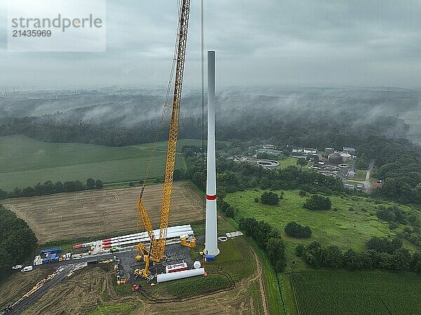 Dorsten  North Rhine-Westphalia  Germany  construction of a wind turbine  the first wind turbine at the Große Heide wind farm. The rotor blades are ready for assembly. A large mobile crane places the tower elements  the rings  on top of each other  Europe