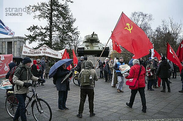 25.11.2023  Berlin  Germany  Europe  In the run-up to a peace demonstration  a demonstrator with a red Soviet flag stands at the Soviet Memorial in the Tiergarten district with a T-34 tank in the background. Several thousand people demonstrate for peace at the Brandenburg Tor in Berlin's Mitte district under the title 'No to wars - stop the arms madness  shape a peaceful and just future'. One of the central demands of the rally is negotiations with Russia. In addition to keynote speaker and former Left Party politician Sahra Wagenknecht  German journalist and publicist Gabriele Krone-Schmalz also spoke at the demonstration  Europe