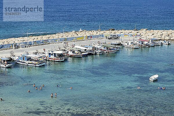 Paphos  Cyprus  September 13 2020: Small fishing marina with tourists relaxing and swimming in the sea during summer. Akamas Peninsula  cyprus  Europe