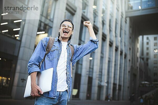 Man Sitting Listening Music Earphones Concept. Cheerful young guy listening the music