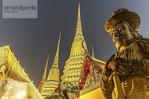 Giant Farang Guard and Chedi of the Buddhist temple Wat Pho at dusk  Bangkok  Thailand  Asia