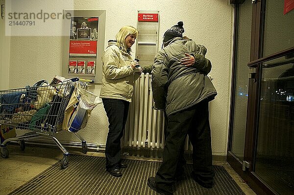 Germany  Berlin  07.01.2011  cold bus of the Berlin City Mission  Katja Klünder (volunteer) speaks to Benno and Horst (names changed) in the ATM room of a savings bank at Kleistpark  Europe