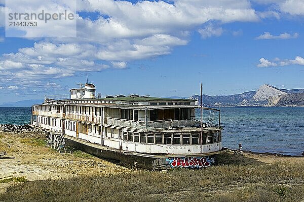 An old abandoned river boat stands on the ground near the sea. Kapsel bay  Crimea. Sunny day in September