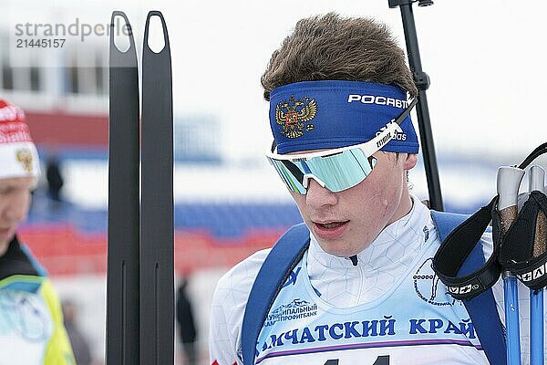 Russian sportsman biathlete Artem Amirbekov Saint Petersburg at finish after skiing and rifle shooting. Open regional youth biathlon competitions East Cup. Kamchatka Peninsula  Russia  April 12  2019  Europe