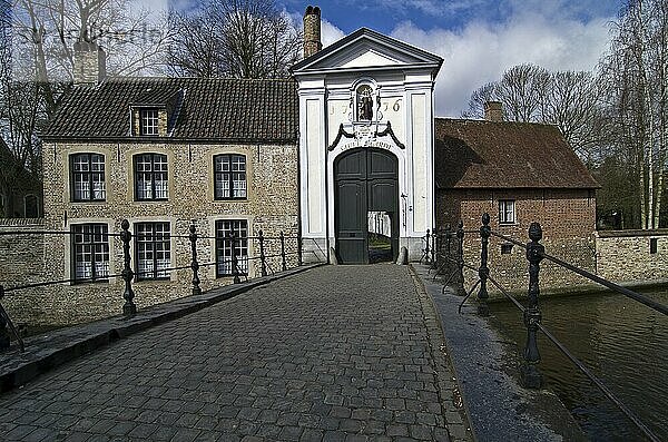 The bridge leading to the gate of Beguinage Bruges  Belgium  Europe