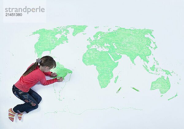 Top view of young girl drawing a map of the world