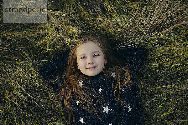 Smiling girl lying down on grass