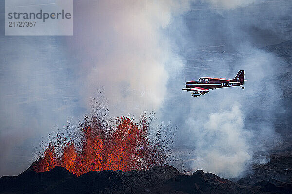 A plane flies over a lava eruption from a fissure near the Bardarbunga volcano in Iceland's Holuhraun lava field area