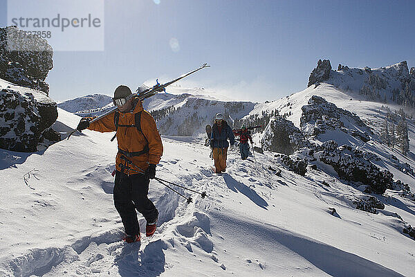 Skiers and a snowboarder hiking in the Kirkwood Backcountry. Kirkwood Ski Resort  Kirkwood California.