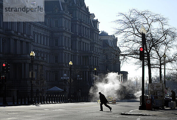 A man crosses the street in front of a cloud of steam coming from a sewer in Washington  D.C.  on December 30  2007.