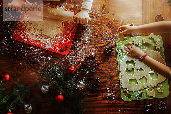 Kids cutting dough with Christmas cookie cutters