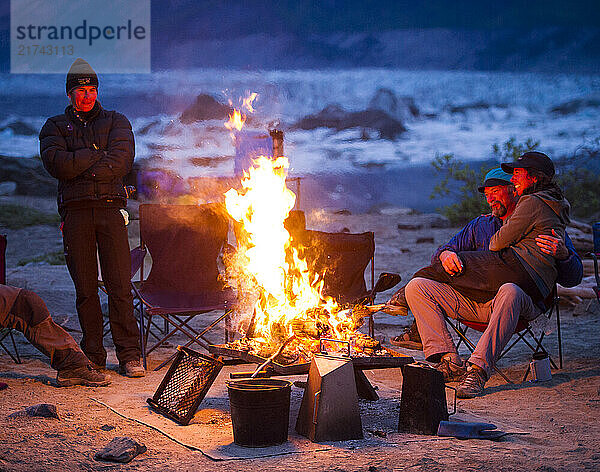 Group of rafters enjoying a campfire along the shores of Lowell Lake  Alsek River