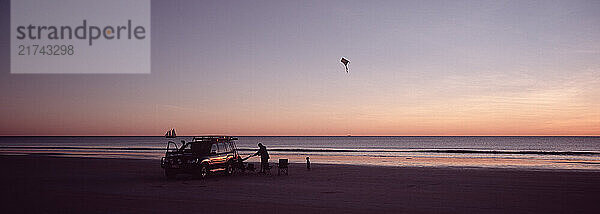 A Family picnicking at sunset on Cable Beach in Broome   Western Australia .