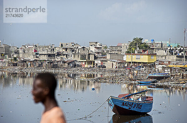 A pedestrian crosses a bridge over the river of Cap Haitien  Haiti on July 23  2008. The severely polluted river - contaminated with garbage and sewage - flows out to the Atlantic Ocean.