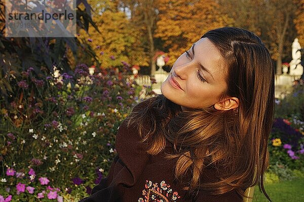 Outdoor sunset portrait of a young pretty woman in autumn colours