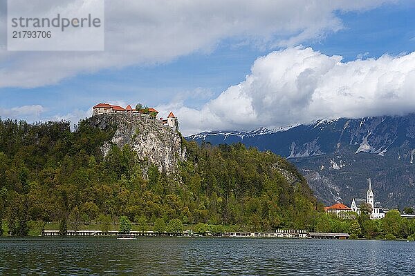 A castle and a church lie under a cloudy sky near a lake  Lake Bled  Lake Veldes  Blejsko jezero  Bled  Veldes  Feldes  Upper Carniola region  Gorenjska  Slovenia  Balkans  Europe