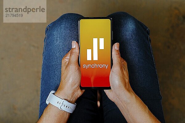 In this photo illustration  the Synchrony logo is displayed on a smartphone mobile