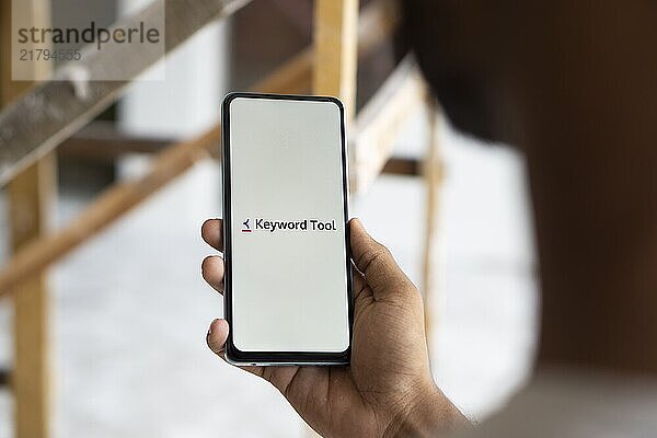 keyword tool logo is displayed on smartphone. Keyword Tool is a free online keyword research tool