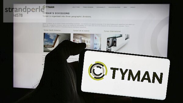 Stuttgart  Germany  05-30-2024: Person holding smartphone with logo of British building products company Tyman plc in front of website. Focus on phone display  Europe