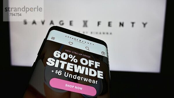 Stuttgart  Germany  05-15-2024: Mobile phone with website of US fashion company Savage X Fenty in front of business logo. Focus on top-left of phone display  Europe