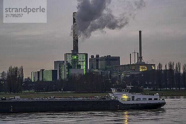 The Lausward combined heat and power plant in Düsseldorf  gas and steam turbine power plant  operated by Stadtwerke Düsseldorf and EnBW  on the Rhine  green illuminated city window  the chimney of the Fortuna power plant unit  the power plant generates electricity  also traction current and district heating  North Rhine-Westphalia  Germany  Europe