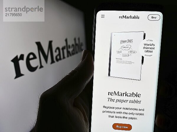 Stuttgart  Germany  03-28-2024: Person holding cellphone with webpage of Norwegian e-reader company reMarkable AS in front of business logo. Focus on center of phone display  Europe