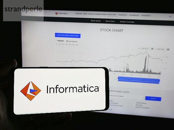 Stuttgart  Germany  06-06-2024: Person holding mobile phone with logo of American software development company Informatica Inc. in front of web page. Focus on phone display  Europe
