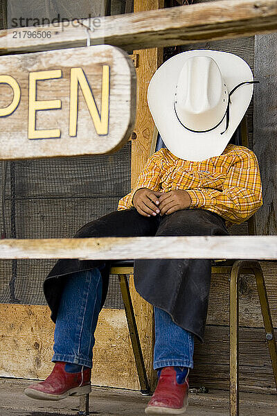 Young cow boy on porch  Wyoming