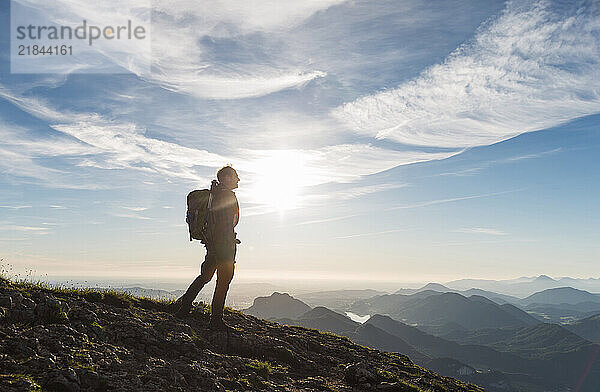 Man with backpack standing on top of mountain