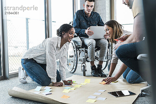 Young businesswomen discussing strategy with colleagues in office